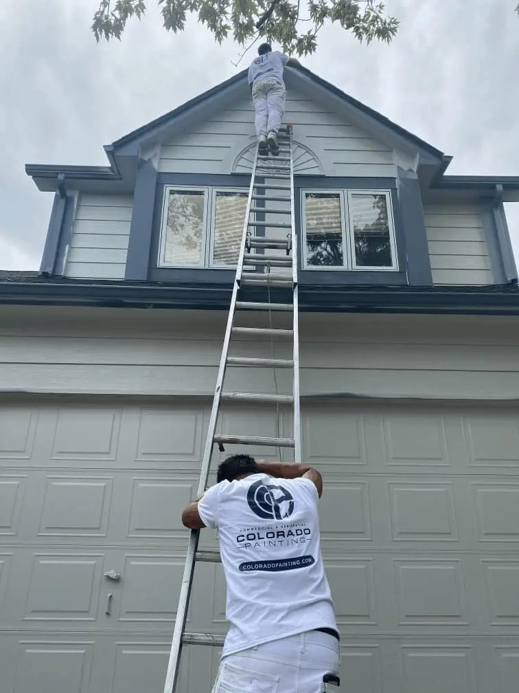 Man climbing on a ladder to paint the house